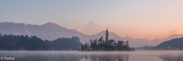 Abendstimmung am See. Im Hintergrund sieht man eine Kirche